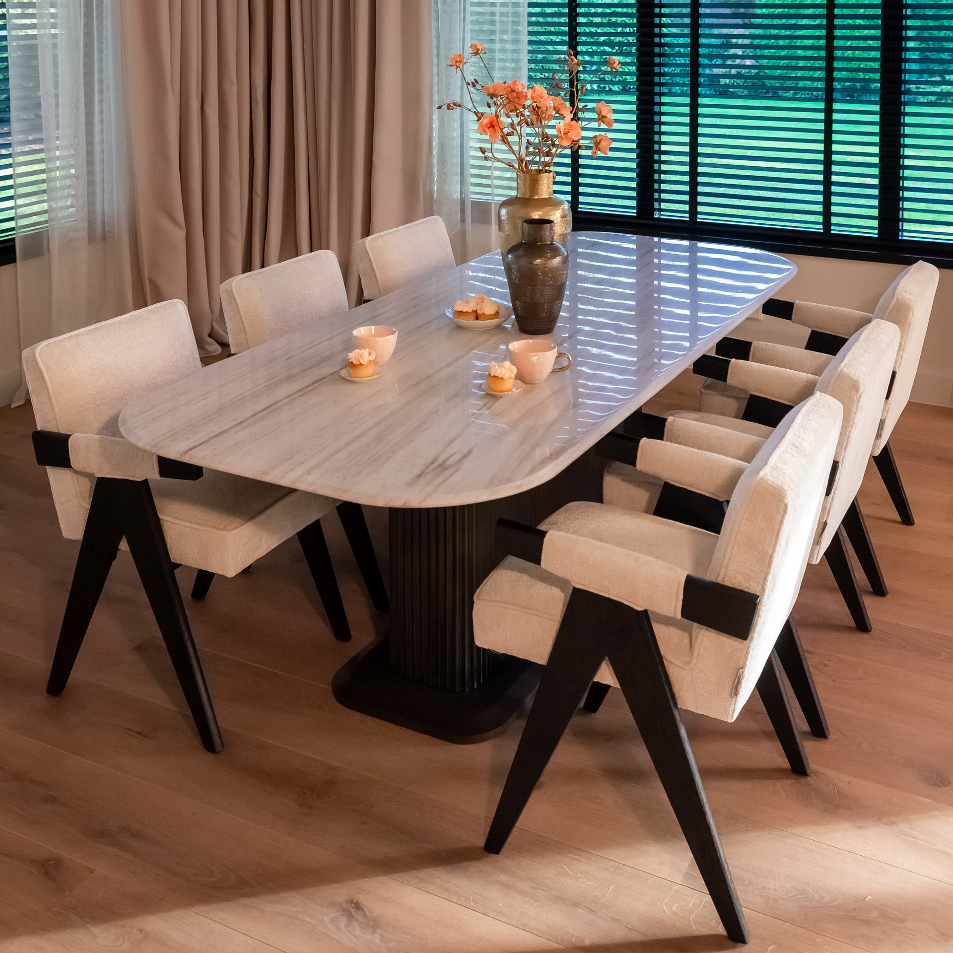 Salle à manger haut de gamme avec table en marbre blanc et fauteuils en bouclette crème