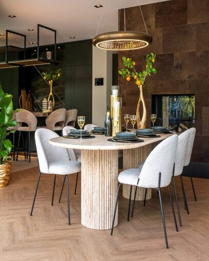 Salle à manger haut de gamme avec table ovale en travertin, chaises bouclette grises et suspension dorée